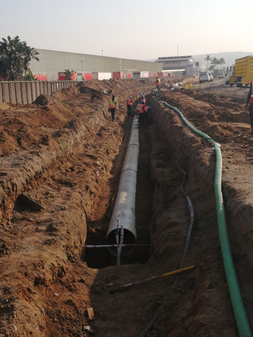 Pipe network being laid in an excavated trench